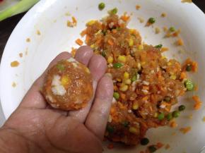 手上抹少许油防粘，取适量肉馅团成一个圆子