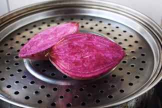 紫薯切开放在蒸锅里蒸熟。