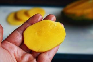 将芒果切成椭圆型的薄片。