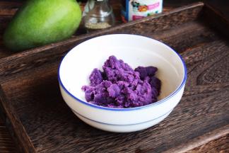 将紫薯泥放在容器里，放入2勺的炼乳，搅拌均匀。