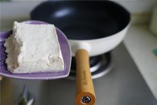 轻奢派不粘锅里加入少许的油，再将豆腐片至锅里。