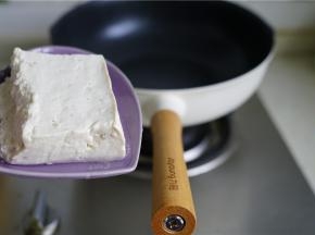 轻奢派不粘锅里加入少许的油，再将豆腐片至锅里。