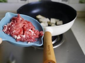 煎至豆腐微微有点脆壳状，再划至一边将牛肉丝下锅煸香。