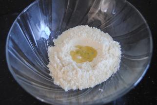 杏仁粉和糖粉混合均匀后过筛，在tpt中间挖个小坑，倒入蛋清1，再轻轻盖住