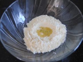 杏仁粉和糖粉混合均匀后过筛，在tpt中间挖个小坑，倒入蛋清1，再轻轻盖住