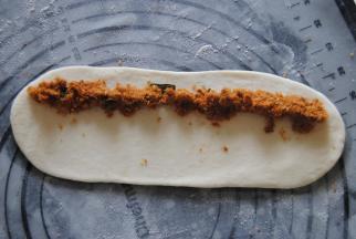 均匀的放上肉松，从一端卷起，卷的时候尽量收紧。