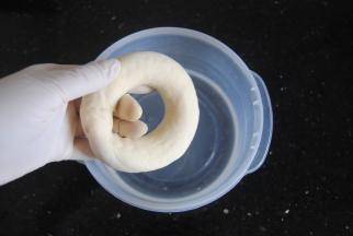 面团提前20分钟左右取出，先配备好碱水，把碱倒入水内，轻轻搅拌融化即可，带着手套抓起面团放入碱水，两面浸泡各20秒左右