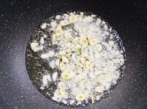 起锅烧油，放入蒜瓣爆香。