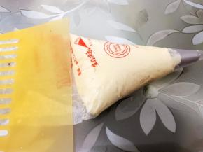 裱花袋里装上曲奇花嘴，加入面糊用刮板推刮到最下面