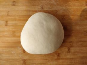 将面团取出后在案板上揉匀。可以看到现在的面团光滑不粘手，比制作吐司的面团稍硬一些，但是对整形面包来说正好合适。