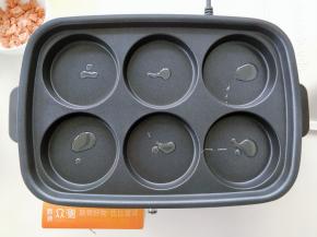 预热摩飞电烤锅，再每个圆饼烤盘上滴少许油，用毛刷刷匀。