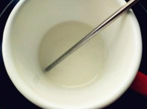 细砂糖加水，倒入小口的搪瓷杯中，小火加热至118度离火，中途不要搅动。不粘杯壁能避免糖水反砂，用电陶炉加热比电磁炉均匀，操作时不要开吸油烟机，会使表面空气流动过快，温度不一致会反砂。