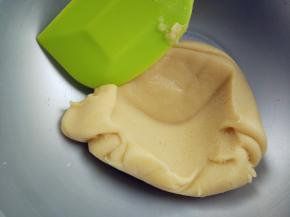 将tpt与埋在中间的蛋清混合均匀。加入1/3蛋白霜，压拌至完全融合。