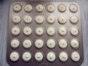 装入中号圆口裱花嘴的大号裱花袋，在模具上挤出形状。我用的是学厨的不粘曲奇马卡龙模。