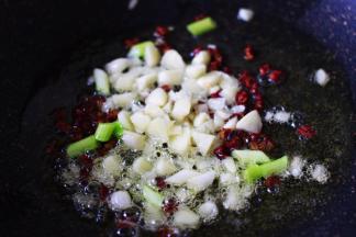 热锅倒入花生油烧至六成热时，加入花椒粒小火慢慢炸出香味后，放入葱姜丝爆香。