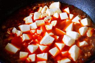 加入提前焯水的豆腐，再加入鸡精和白糖调味。