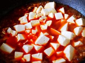 加入提前焯水的豆腐，再加入鸡精和白糖调味。