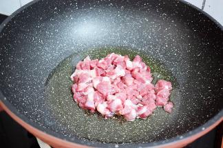 锅中倒入适量的油烧热，放入猪肉翻炒至变色变白