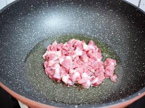 锅中倒入适量的油烧热，放入猪肉翻炒至变色变白