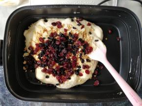 将椰蓉（留出少许）、蔓越莓干、蓝莓干、花生碎、烤杏仁片倒入锅中搅匀。