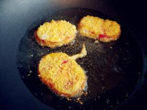 不粘锅中放少许色拉油，小火烧至五成热，放入西红柿片。为了节省油，我用了煎的方式，也可以用炸的。