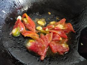 蒜片爆锅后，倒入切成大块的西红柿，炒软出汁到成酱的样子