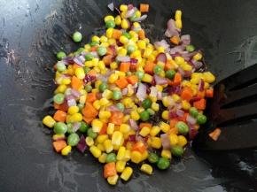 炒锅中倒入少许刚才炸鱼的油，中火烧热后将洋葱丁倒入，炒至断生，再倒入什锦菜，炒至断生