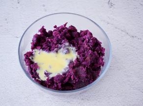 把蒸熟的紫薯加入炼乳，用料理棒打成细腻的泥状
