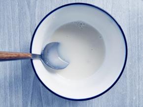 舀出两勺约30毫升温热的牛奶液，倒入吉利丁中，拌匀到完全融化，放在一边备用。