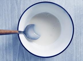 舀出两勺约30毫升温热的牛奶液，倒入吉利丁中，拌匀到完全融化，放在一边备用。