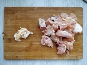 先将鸡大腿用水冲洗一下，用刀刮掉多余的肥油，再用斩骨刀纵向剁成大块，把骨头旁边的肉分成小块。