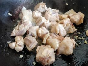 在锅中倒少许油，爆香大蒜后，倒入鸡块翻炒，把刚才焯水后鸡块中多余的水分炒出来一些，这样一会儿再炖更容易入味。