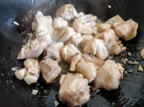 在锅中倒少许油，爆香大蒜后，倒入鸡块翻炒，把刚才焯水后鸡块中多余的水分炒出来一些，这样一会儿再炖更容易入味。
