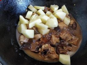 盖上锅盖，用中火炖10分钟左右，汤汁差不多剩原来的三分之一，这时将刮皮切块的土豆倒入锅中，用锅铲翻匀后改小火，盖上锅盖焖5分钟左右。