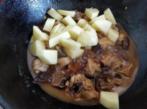 盖上锅盖，用中火炖10分钟左右，汤汁差不多剩原来的三分之一，这时将刮皮切块的土豆倒入锅中，用锅铲翻匀后改小火，盖上锅盖焖5分钟左右。