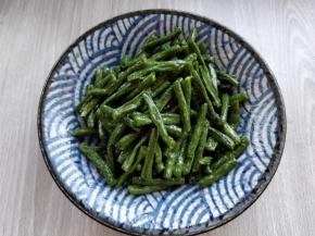 在豇豆中加适量盐和生抽拌匀后，倒入盘中。