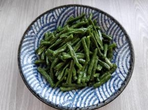 在豇豆中加适量盐和生抽拌匀后，倒入盘中。