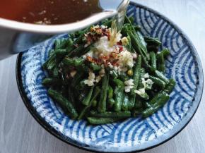 把蒜末和辣椒碎堆在豇豆上，将刚才打油焯的植物油烧热，浇1勺在上面，会发出吱啦的声响，满屋飘香。用筷子拌匀就可以吃啦。