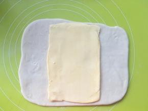 冰箱取出冷冻的黄油片，裁掉保鲜袋，将黄油片放在面片中间
