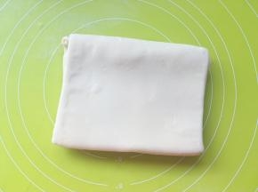 将长条的两侧向中间对折在一起，之后再对折一下，就像叠被子一样将面片折成四折

