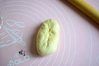 再把包好豆沙馅的面团，揉成圆柱形