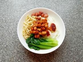 取一个碗，放入煮好的米线，依次放入青菜、豆腐皮、花生米和炒好的豆腐干，根据自己的口味放盐和鸡精(喜欢吃辣椒的可以放一些辣椒)。