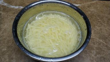 土豆去皮刨丝，用水浸泡三次，去掉淀粉质
