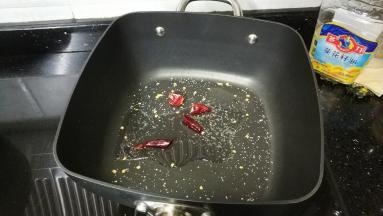 不粘锅放入油、糖、盐、干辣椒爆香