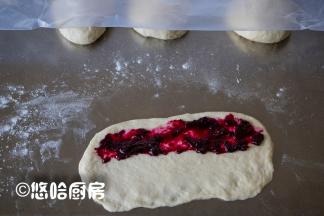 取一个醒发后的面团，压扁擀开成长方形，中间放一点果酱。