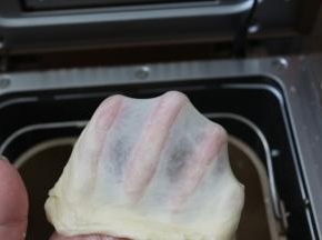 再开启面包机和面功能，再将面团揉到完全扩展性，能拉出薄膜来即可