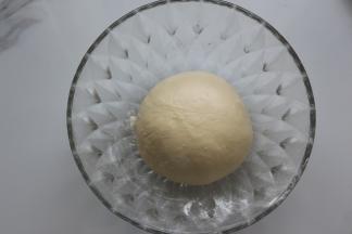 揉好的面团，拿出来揉成圆形，再放在大盆里，盖上保鲜膜进行基本发酵母，这时面团的面温为26度，发酵的温度为28度，发酵的时间大概是60分钟左右