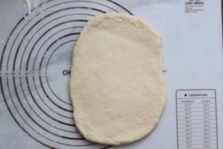 松弛好的面团，拿出来一个先擀成片状，再翻面过来