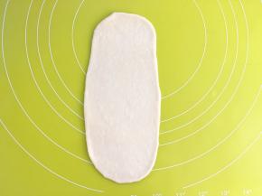 取一份松弛好的面团，用擀面杖擀成长条
