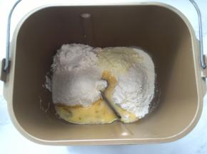 面包桶内加入高筋面粉、低筋面粉、酵母、奶粉、炼乳、细砂糖跟全蛋液
